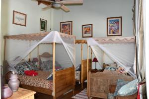 a bedroom with two beds and a ceiling fan at Triple Room Bed and Breakfast main House in Guillet