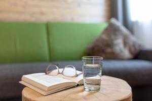 ein Glas Wasser und ein Buch auf einem Tisch in der Unterkunft Residence Dilitz in Reschen