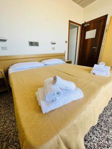 a hotel room with two towels on a bed at Hotel Columbia Frontemare in Rimini