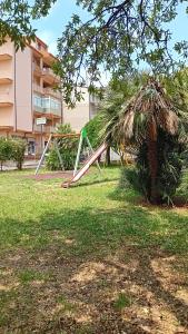 un parque infantil en un parque junto a una palmera en Al primo piano 22, en Castrovillari