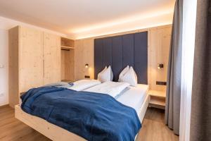 ein Schlafzimmer mit einem großen weißen Bett mit blauer Bettwäsche in der Unterkunft Residence Dilitz in Reschen