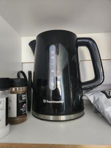 a black tea kettle sitting on top of a counter at Baywatch Lighthouse Cottages & Motel in Brackley Beach