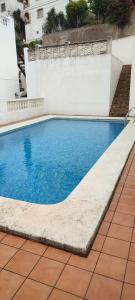 una piscina con acqua blu in un edificio di Appartements 10 minutes des plages Oliva Espagne près de Gandia environ des plage Playa de Gors a La Font D´En Carròs