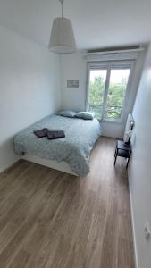een slaapkamer met een bed en een houten vloer bij Flat for 6 persons 10 minutes from CDG Airport in Le Blanc-Mesnil
