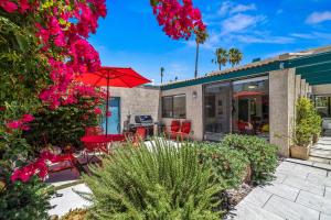 a patio with a table and chairs and a red umbrella at North De Anza Manor Permit# 615 in Palm Springs