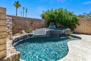 a swimming pool with a waterfall in a backyard at North De Anza Manor Permit# 615 in Palm Springs