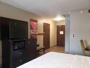 a bedroom with a bed and a flat screen tv at Hampton Inn Greensburg in Greensburg