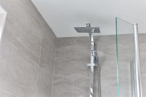 een douche met een douchekop in de badkamer bij Properties Unique Dene Rooms - Single Room in Newcastle upon Tyne
