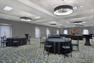 a banquet hall with black tables and chairs at Hampton Inn Gallatin in Gallatin