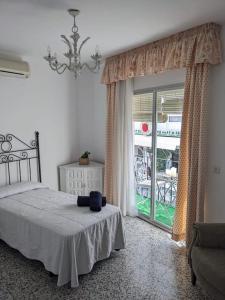 a bedroom with a bed and a large window at Luminosa casa familiar céntrica in Marbella