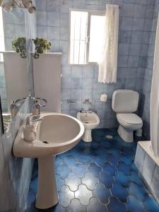 bagno piastrellato blu con lavandino e servizi igienici di Luminosa casa familiar céntrica a Marbella