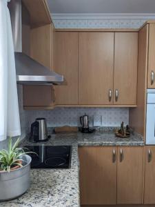 una cucina con armadi in legno e piano cottura. di Luminosa casa familiar céntrica a Marbella
