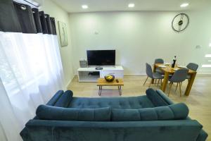 een woonkamer met een blauwe bank en een tafel bij Apartment Sara Sinj in Sinj