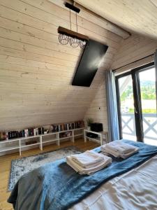 1 dormitorio con 1 cama en una pared de madera en Śnieżna Chatka - Sosnówka Karpacz, en Sosnówka