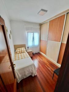 a small bedroom with a bed and a window at Apartamento luminoso Santander in Santander