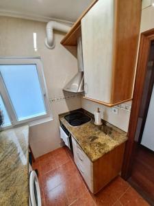 Una pequeña cocina con estufa y fregadero. en Apartamento luminoso Santander, en Santander