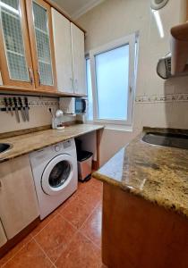 a kitchen with a washing machine and a window at Apartamento luminoso Santander in Santander