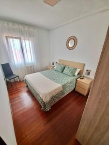 Un dormitorio con una cama y una silla dentro. en Apartamento luminoso Santander, en Santander