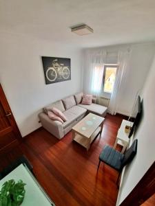 ein Wohnzimmer mit einem Sofa und einem Tisch in der Unterkunft Apartamento luminoso Santander in Santander