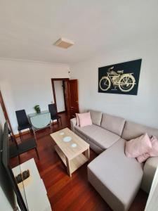 ein Wohnzimmer mit einem Sofa und einem Tisch in der Unterkunft Apartamento luminoso Santander in Santander