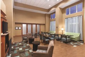 a lobby with a waiting room with tables and chairs at Hampton Inn & Suites Greenfield in Greenfield