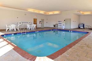 a large swimming pool with chairs and a table at Hampton Inn Grand Island in Grand Island