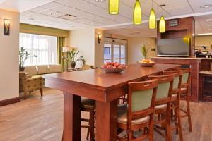 cocina y comedor con mesa de madera grande y sillas en Hampton Inn Grand Island, en Grand Island