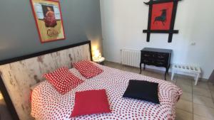 a bedroom with a bed with red and black pillows at Hotel Casa Grande in Constantina