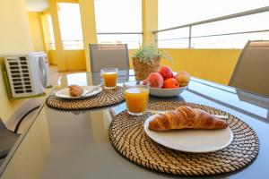 a table with two plates of food and orange juice at C07 - 3 Bed Luxury Penthouse in Downtown Lagos in Lagos
