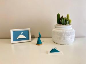 una mesa con una planta y una foto y un jarrón en Luna Nuova Suites, en Nápoles