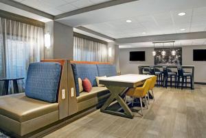 a waiting room with a couch and a table and chairs at Hampton Inn Greenville/Woodruff Road in Greenville