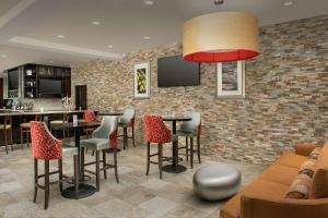 eine Bar mit Tischen und Stühlen und einer Ziegelwand in der Unterkunft Hilton Garden Inn Gallup in Gallup