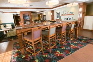 a kitchen with a bar with chairs on a rug at Hampton Inn Hadley-Amherst Area in Hadley