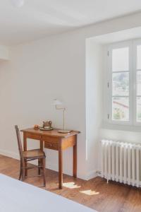 a desk with a chair and a radiator in a room at Maison Gamboia, chambres et table d'hôtes au calme avec jardin in Hasparren