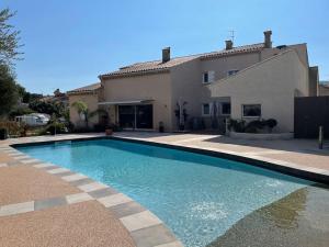 a swimming pool in front of a house at SICILIA VILLA in La Ciotat