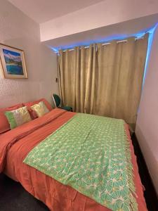 a bedroom with a bed with a green and orange blanket at La Valette in Isola