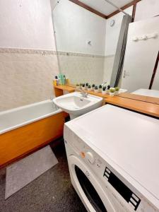 a bathroom with a sink and a washing machine at La Valette in Isola