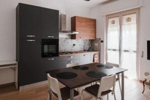 uma cozinha com uma mesa com cadeiras e um armário preto em Casa Rosarè em Montesilvano