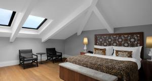 a bedroom with a bed and two chairs and windows at Akka Suites Taksim-Special Class in Istanbul
