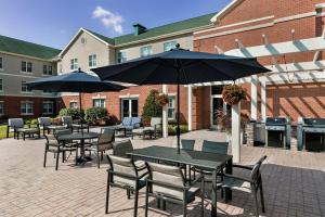 um pátio com mesas e cadeiras com guarda-sóis em Homewood Suites by Hilton Harrisburg East-Hershey Area em Harrisburg