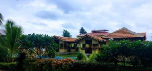 a house with a pool in front of it at Mybhumi Resort in Malshej Ghat