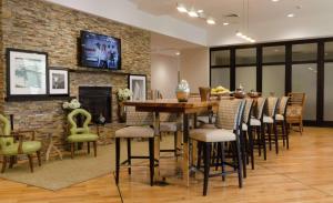 a dining room with a table and chairs and a brick wall at Hampton Inn Hickory in Hickory