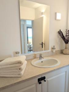 bagno con lavandino e specchio di ALLURA GOLF APPARTEMENT a Saumane-de-Vaucluse