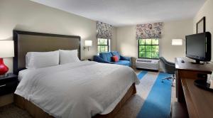 a hotel room with a large bed and a television at Hampton Inn Helen in Helen