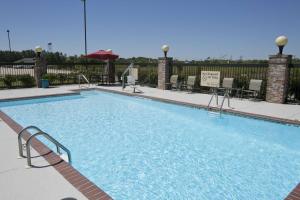 a swimming pool at a hotel with chairs and tables at Hampton Inn & Suites Wiggins in Wiggins
