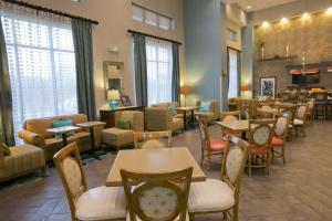 a waiting room with tables and chairs and windows at Hampton Inn & Suites Wiggins in Wiggins