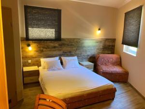 een kleine slaapkamer met een bed en een stoel bij Vila Lago in Veliko Gradište