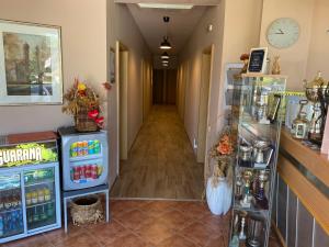 een gang van een winkel met een koelkast en een klok bij Vila Lago in Veliko Gradište