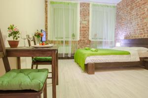 a bedroom with two beds and a desk and a table with green sheets at Apart Hotel Arka in Saint Petersburg