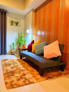 a couch with colorful pillows on it in a living room at Cozynest Condotel Baguio in Baguio